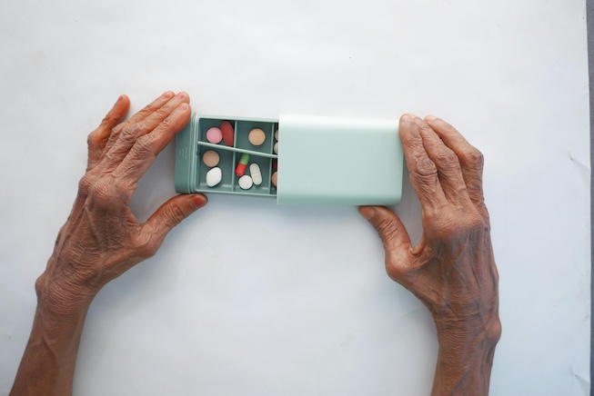 Photo of person holding a pill case.