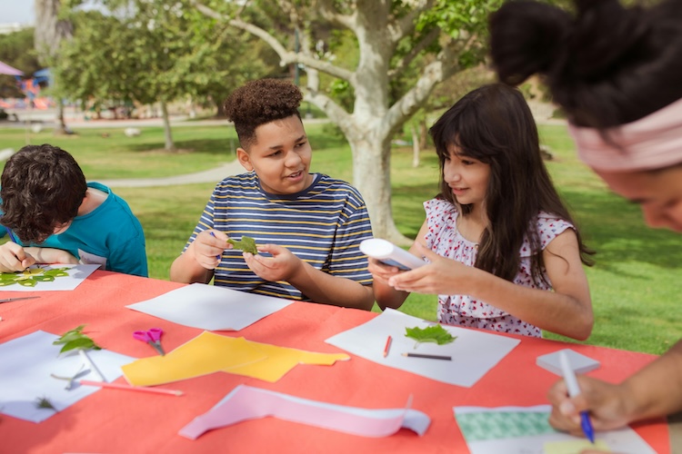 image of children doing crafts outside on a picnic table